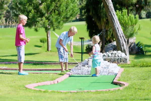 Skupina děti hrají venku minigolf — Stock fotografie