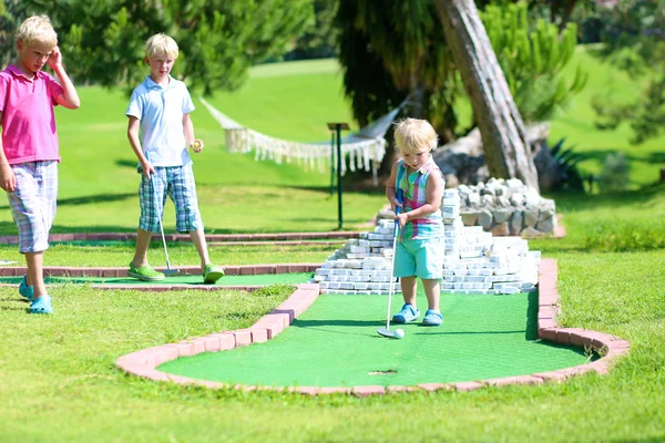 Grupo de crianças jogando mini golfe ao ar livre — Fotografia de Stock