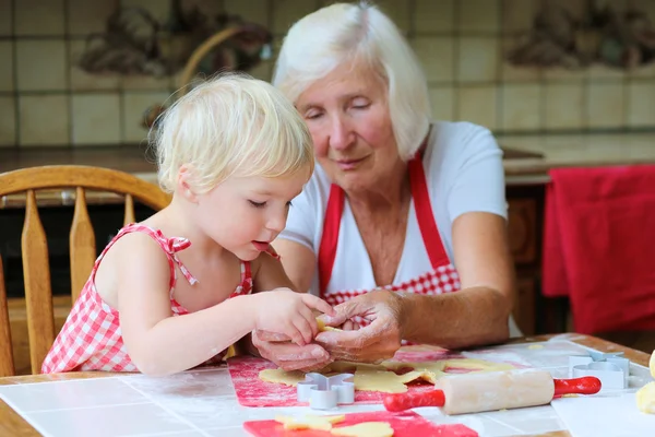 Oma met kleindochter voorbereiding van cookies — Stockfoto