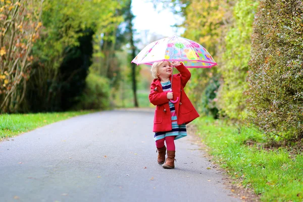 Glückliches Vorschulmädchen, das mit Regenschirm läuft — Stockfoto