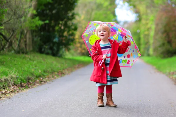 Glada förskolebarn flicka gå med paraply — Stockfoto