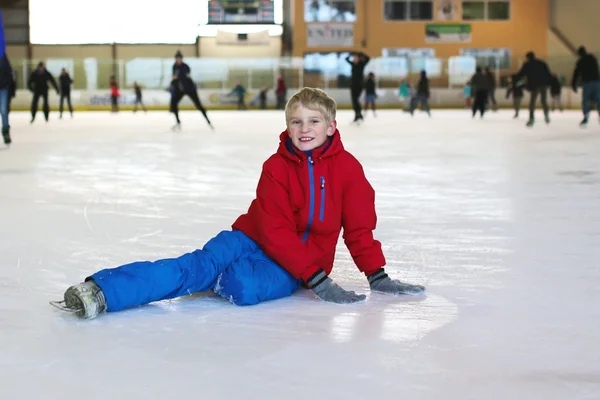 Menino da escola feliz se divertindo no ringue de patinação no gelo — Fotografia de Stock