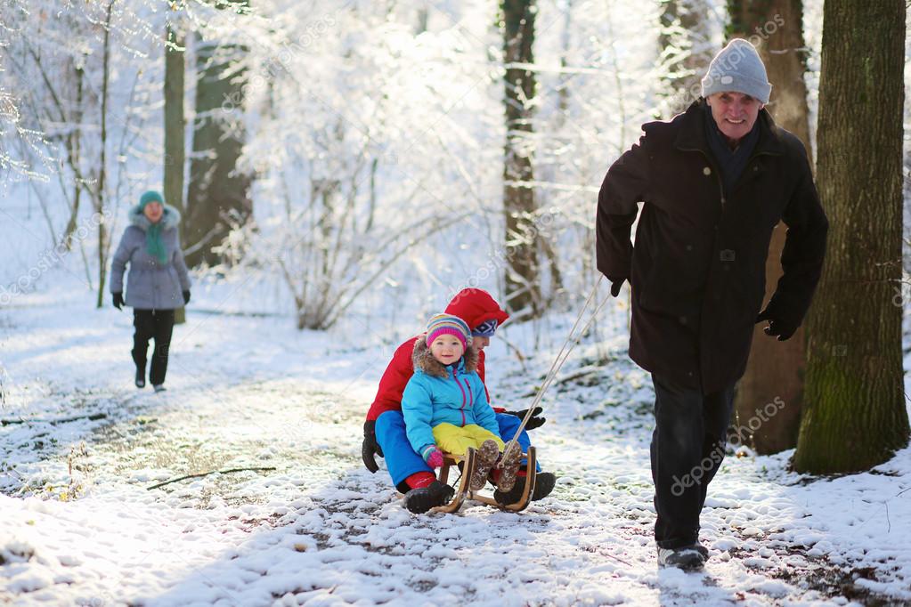 Happy grandfather playing with grandkids in winter