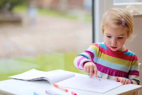 Маленькая девочка рисует в школе или дома — стоковое фото