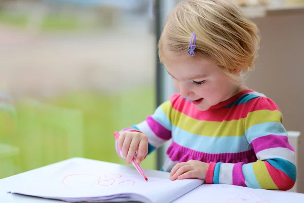 Маленькая девочка рисует в школе или дома — стоковое фото