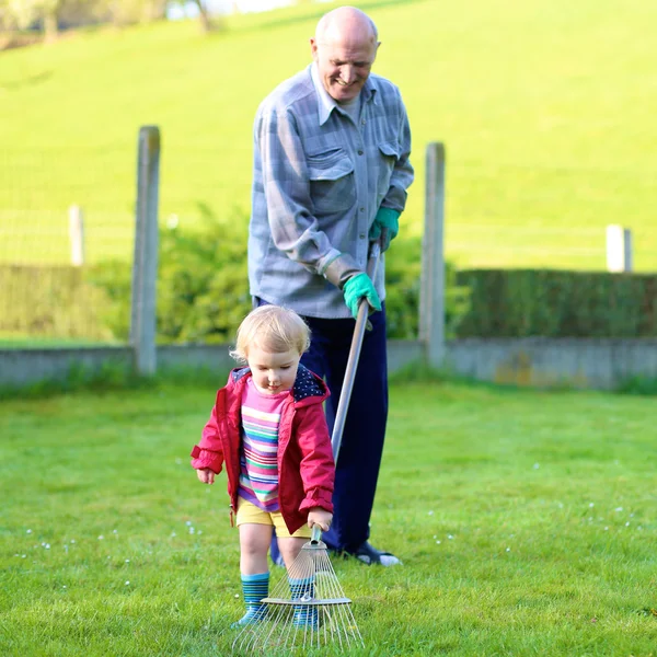Farfar med barnbarn arbetar i trädgården — Stockfoto