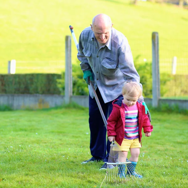 Grandfather with granddaughter working in the garden — Stock Photo, Image