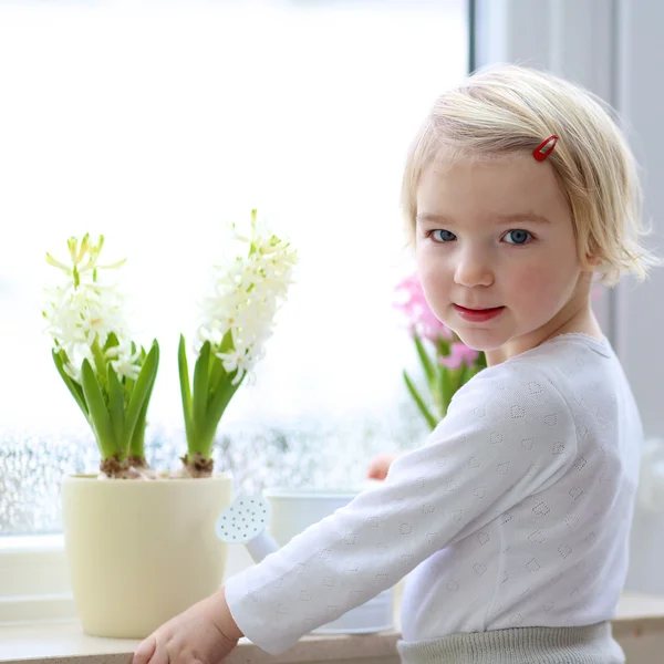 Little girl watering spring flowers — Stock Photo, Image