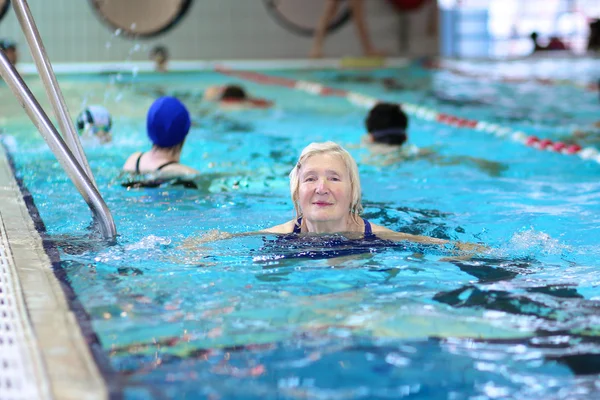 Aktiv senior kvinna simmar i poolen — Stockfoto