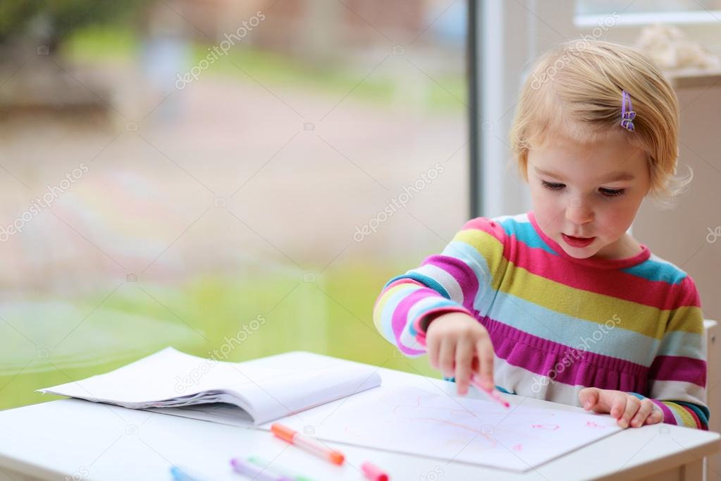 Toddler girl drawing at school or home