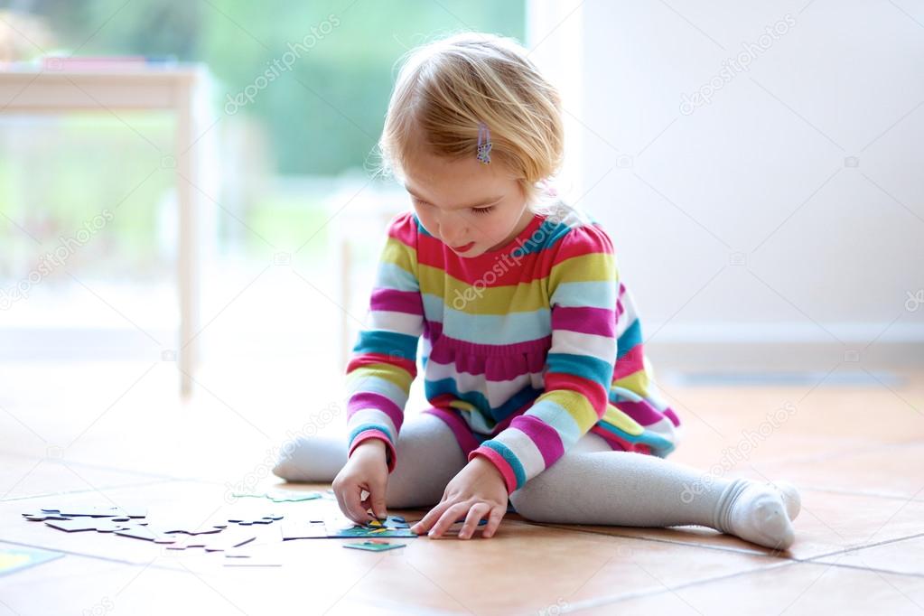 Preschooler girl playing with jigsaw puzzle