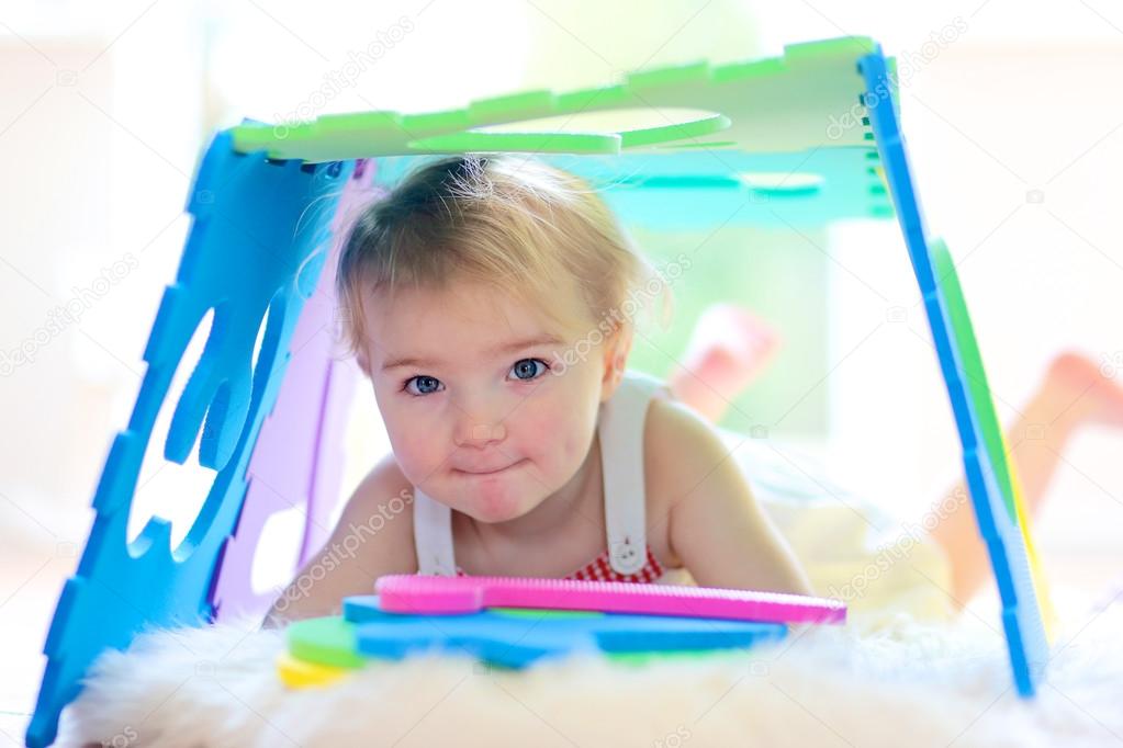 Toddler girl playing with big soft puzzles