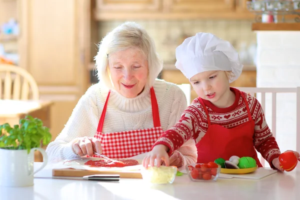 Oma mit Enkelin bereitet Pizza zu — Stockfoto