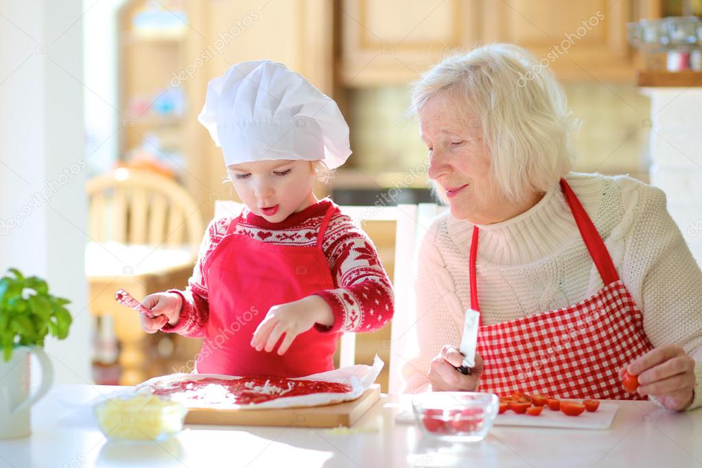 Grandma with granddaughter preparing pizza