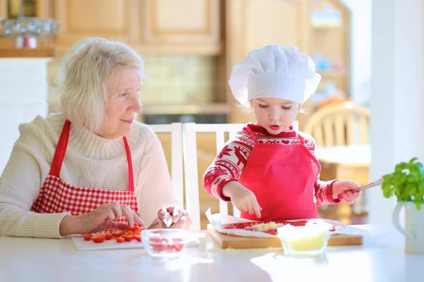 Nagymama és unokája, pizza előkészítése — Stock Fotó