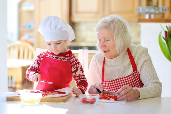 Oma mit Enkelin bereitet Pizza zu — Stockfoto