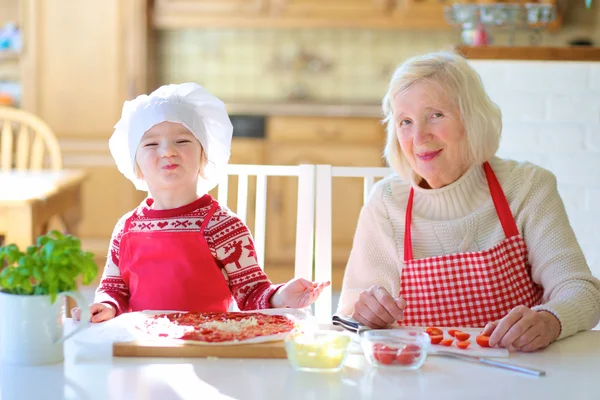 Mormor med barnbarn förbereder pizza — Stockfoto