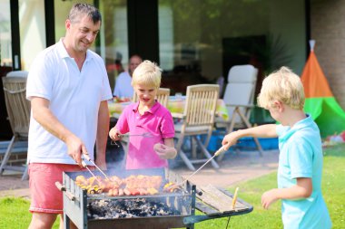 Baba ve oğulları barbekü yaz parti için hazırlanıyor