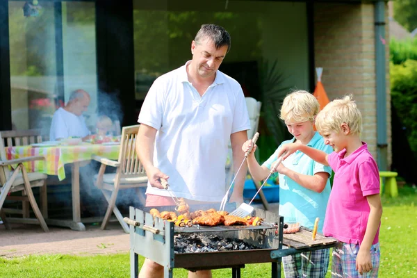 Far och söner förbereder grill för sommarfest — Stockfoto