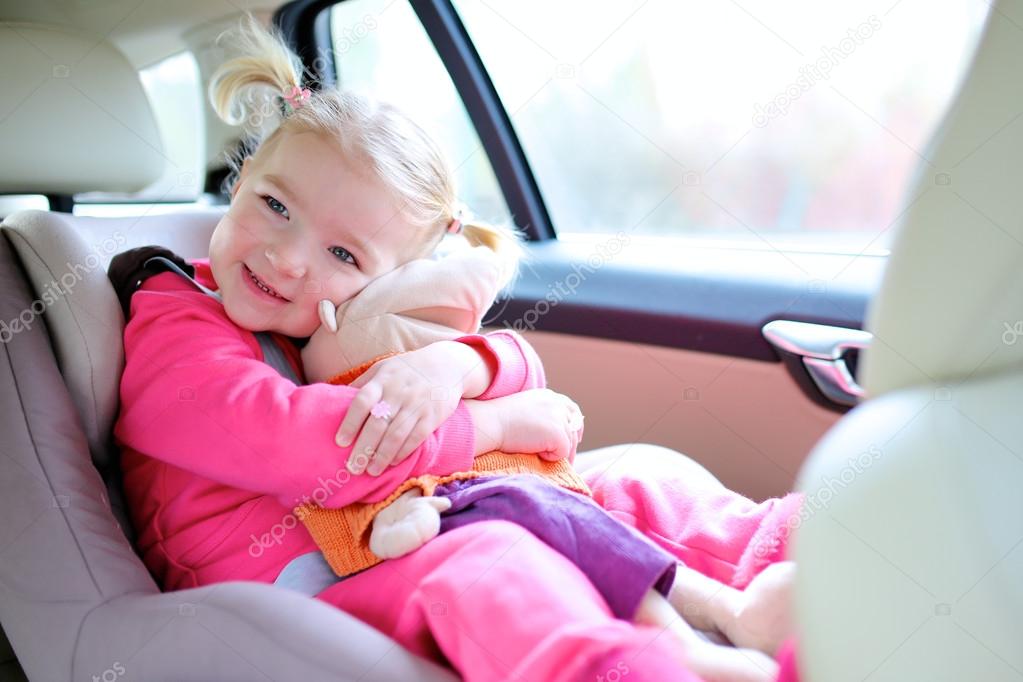 Happy toddler girl enjoying trip in the car