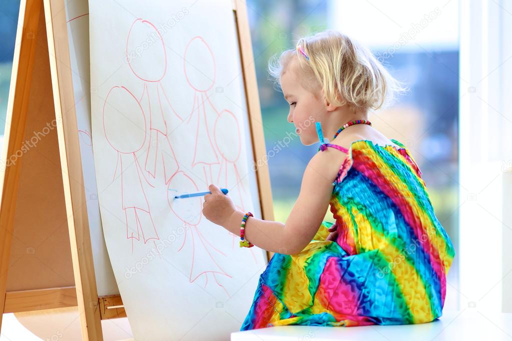 Preschooler girl drawing on paper roll