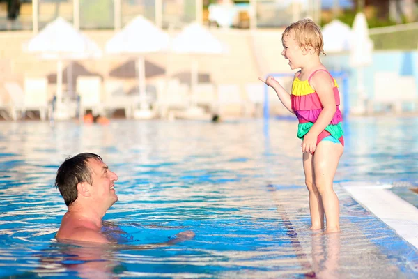 Father and daughter playing in swimming pool — Stock Photo, Image