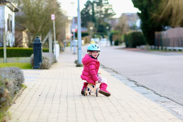 Petit enfant jouant dans la rue à cheval tricycle — Photo