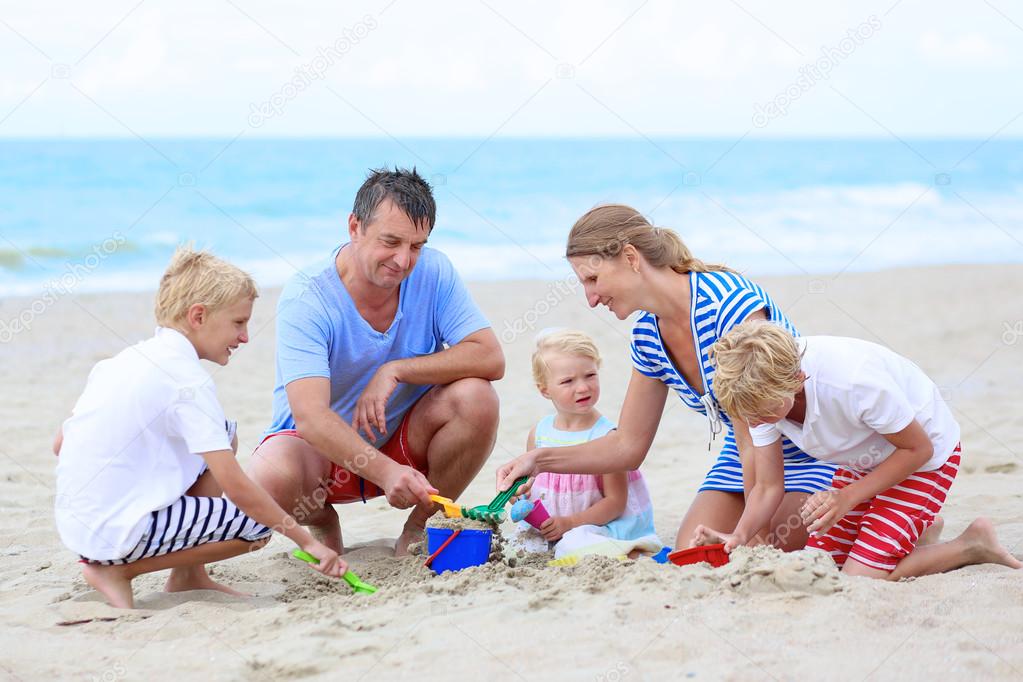 Happy family enjoying summer vacation on the beach