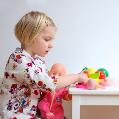 Yürümeye başlayan çocuk kız kapalı bebeklerle oynamaktan