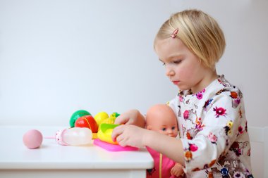 Yürümeye başlayan çocuk kız kapalı bebeklerle oynamaktan