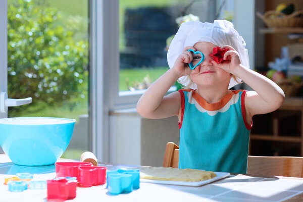 Happy toddler girl preparing cookies