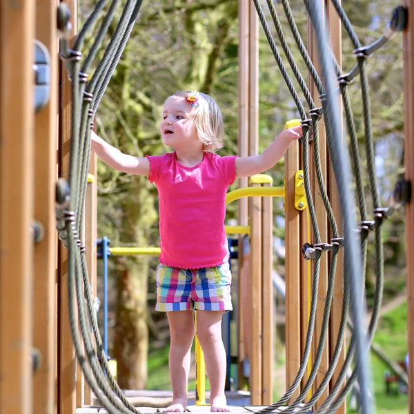 Barn girl har roligt på lekplatsen — Stockfoto