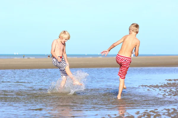 Zwei aktive Jungen spielen am Strand — Stockfoto