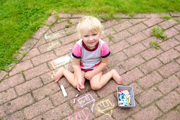 Preschooler girl drawing with chalk outdoors — Stock Photo, Image