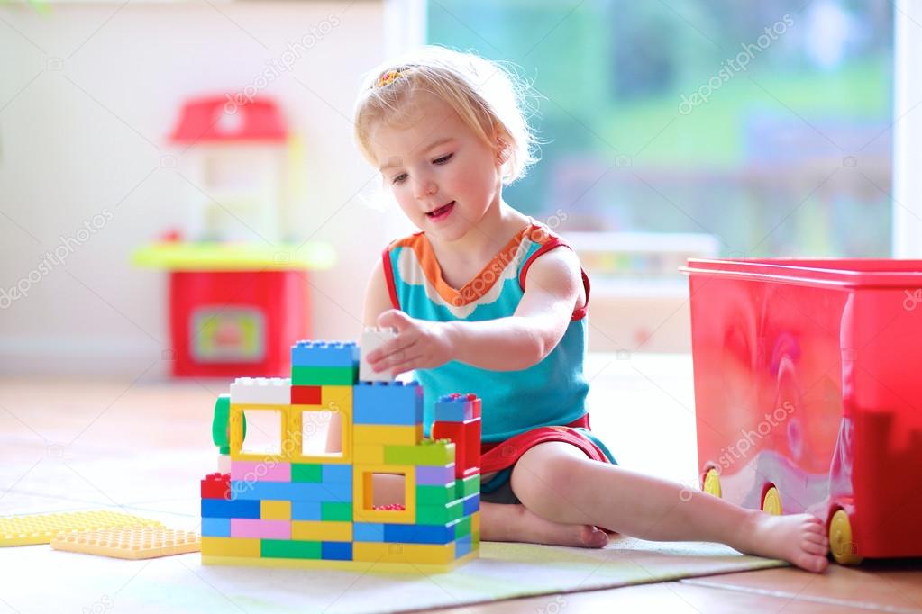 Little girl playing with construction blocks