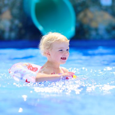 Küçük kız havuzda gülüyor