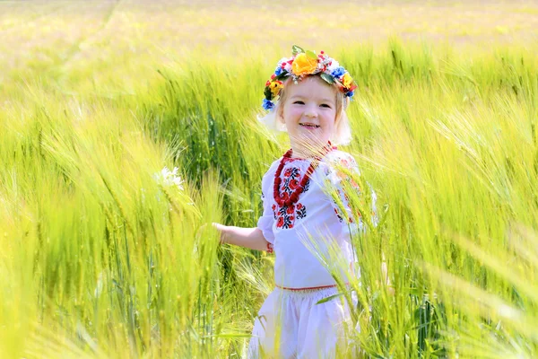 Malá holčička v ukrajinských oblečení hraje v poli — Stock fotografie