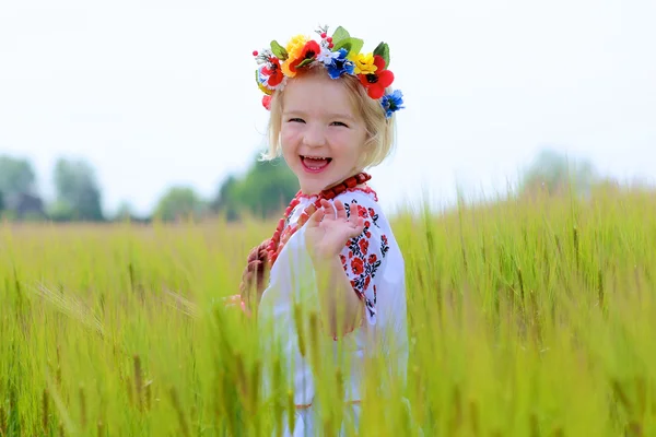 Little girl in Ukrainian dress playing in the field — Stock Photo, Image