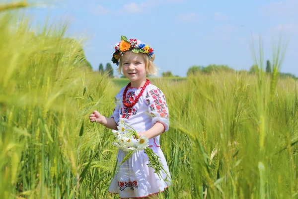 Kleines Mädchen im ukrainischen Kleid spielt auf dem Feld — Stockfoto