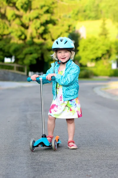 Peuter meisje paardrijden scooter op straat — Stockfoto