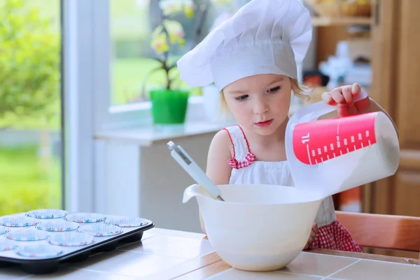 Menina bonito assar pastelaria na cozinha — Fotografia de Stock