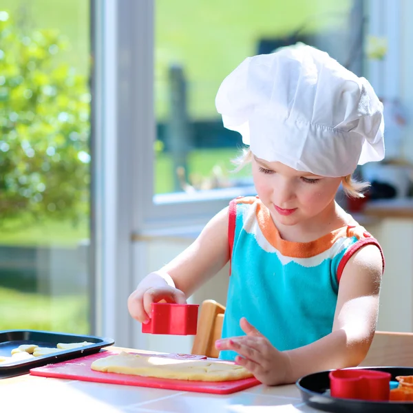 Schattig klein meisje bakken gebak in de keuken — Stockfoto