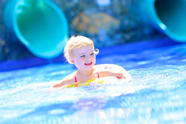 Смеющаяся маленькая девочка плавает в бассейне — стоковое фото
