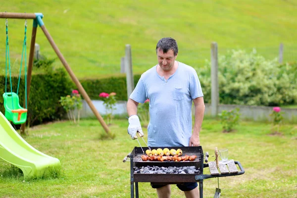 Mann grillt Fleisch im Freien — Stockfoto