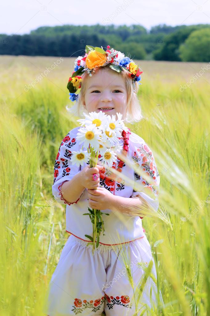 Little girl in Ukrainian dress playing in the field