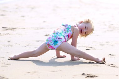 Little girl playing on the beach at summer