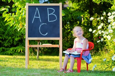 Toddler girl playing teacher with her toys