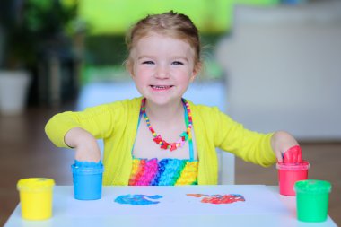 Little girl creating with finger paint clipart