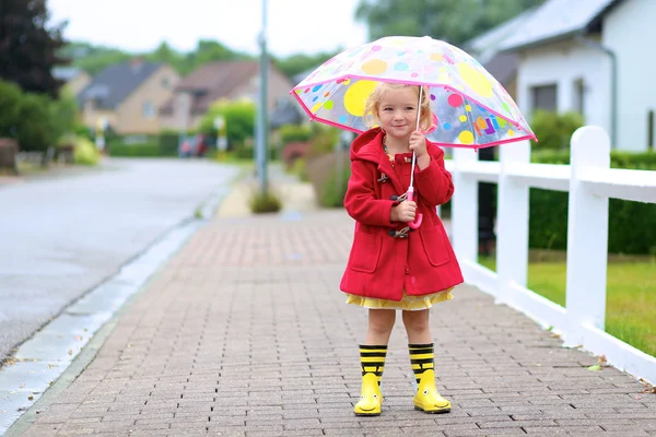 Portrait of playful little girl with colorful umbrella — Zdjęcie stockowe