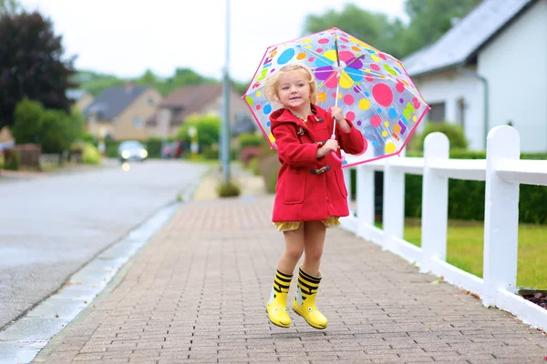 Porträt eines verspielten kleinen Mädchens mit buntem Regenschirm — Stockfoto